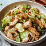 Chinese Chicken Cabbage Stir-Fry with tender chicken, crisp cabbage, and a savory garlic-ginger sauce served in a wok.