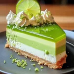 A slice of Lime Mousse Cheesecake with a graham cracker crust, topped with whipped cream and fresh lime zest.