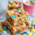 Soft and chewy Easter Cake Mix Cookie Bars, filled with pastel M&Ms and sprinkles, sliced into squares and served on a festive plate.