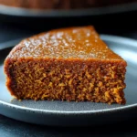 Slice of flourless sweet potato ginger cake topped with whipped coconut cream